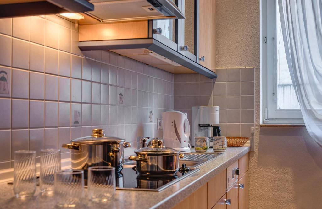 a kitchen with two pots and pans on a stove at Hotel Aquamarin in Kühlungsborn