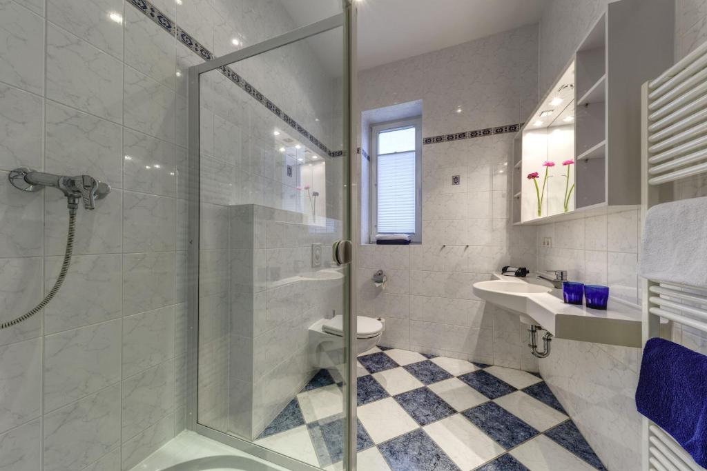 a bathroom with a shower and a toilet and a sink at Hotel Aquamarin in Kühlungsborn