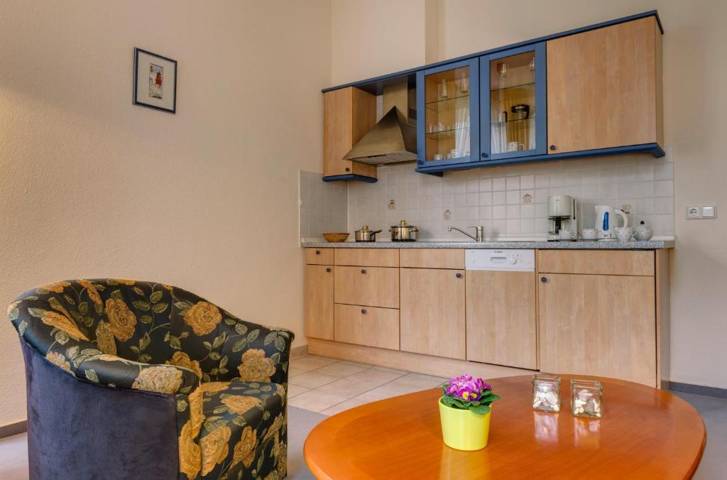 a living room with a table and a kitchen at Hotel Aquamarin in Kühlungsborn
