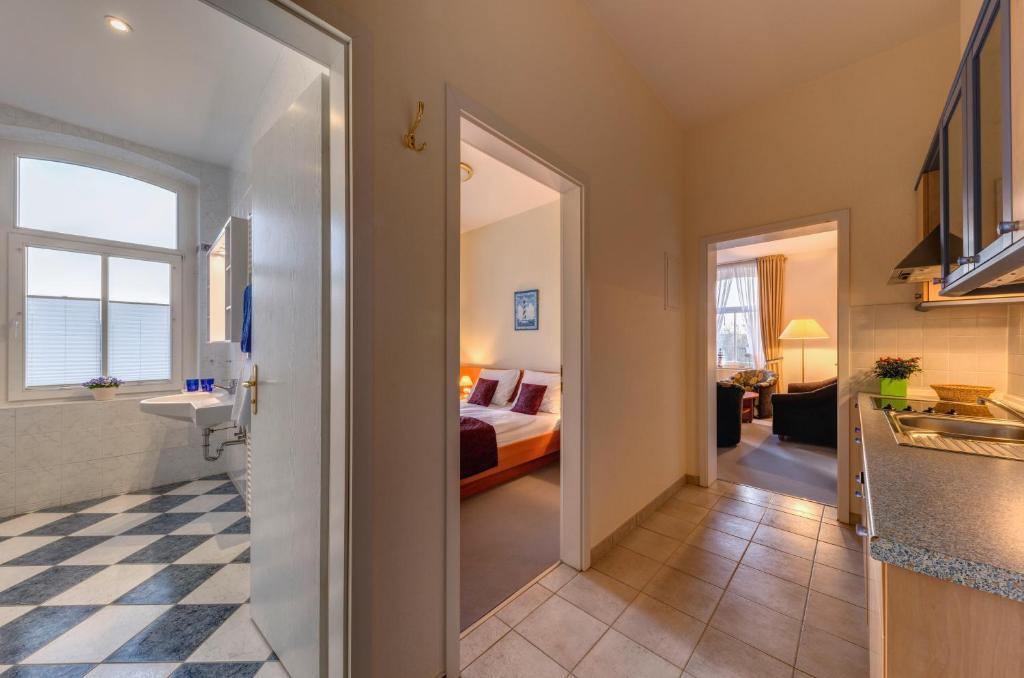 a hallway leading to a room with a bed and a kitchen at Hotel Aquamarin in Kühlungsborn