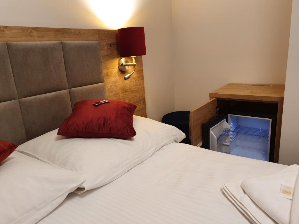 Un dormitorio con una cama con una almohada roja. en Villa Roma przy wyciągu na Szrenicę, en Szklarska Poręba