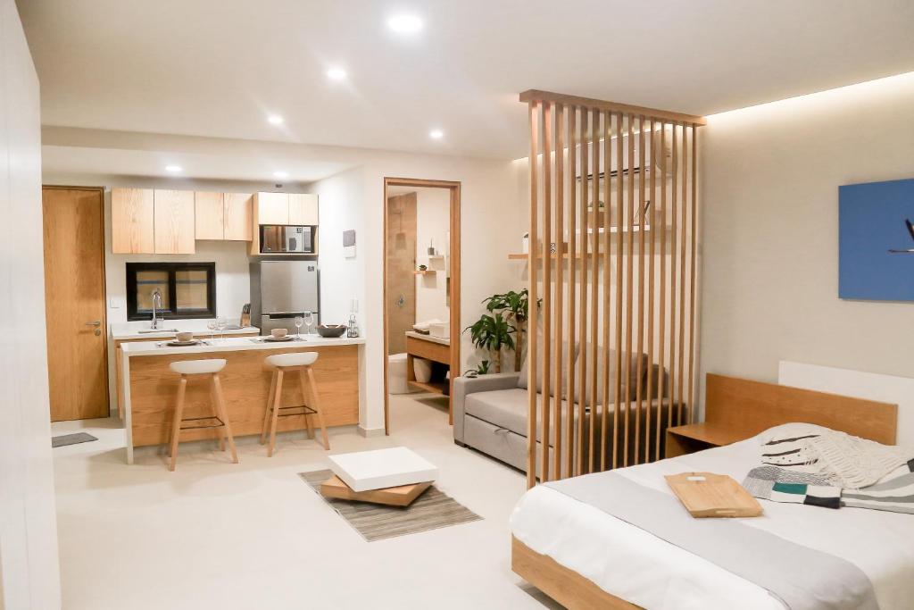 a bedroom with a bed and a kitchen with a counter at Levitat 32 in Playa del Carmen