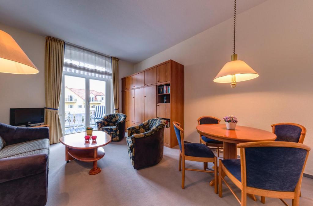 a living room with a table and a dining room at Hotel Aquamarin in Kühlungsborn