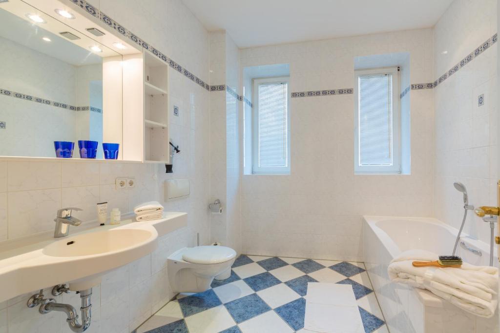a bathroom with a sink and a toilet and a tub at Hotel Aquamarin in Kühlungsborn