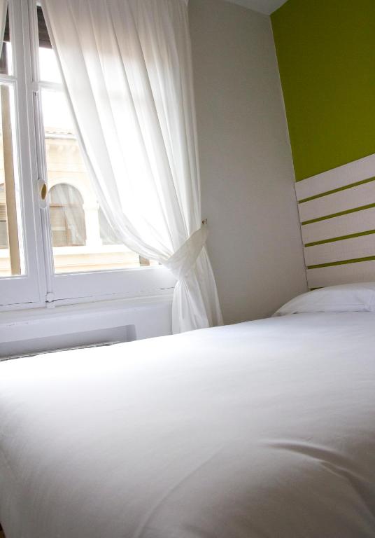 Posteľ alebo postele v izbe v ubytovaní Hostal Boreal Mistral