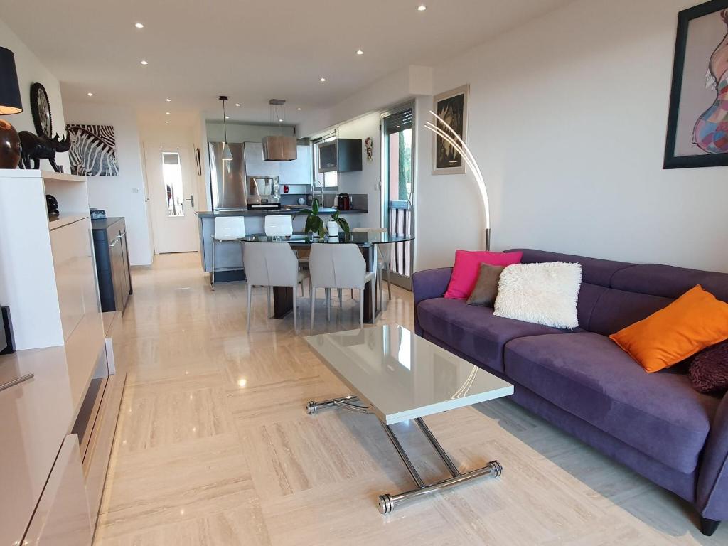 - un salon avec un canapé violet et une table dans l'établissement Classy Apartment in Nice with pool and private parking place, à Nice