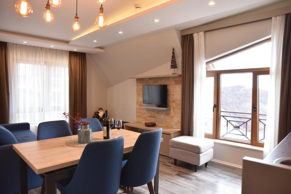 een eetkamer met een tafel en stoelen en een televisie bij Milmari Resort Premier 46 in Kopaonik