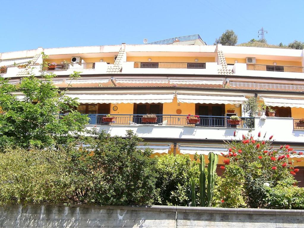 un bâtiment avec des balcons et des plantes devant lui dans l'établissement Apartment in Letojanni/Sizilien 23296, à Letojanni