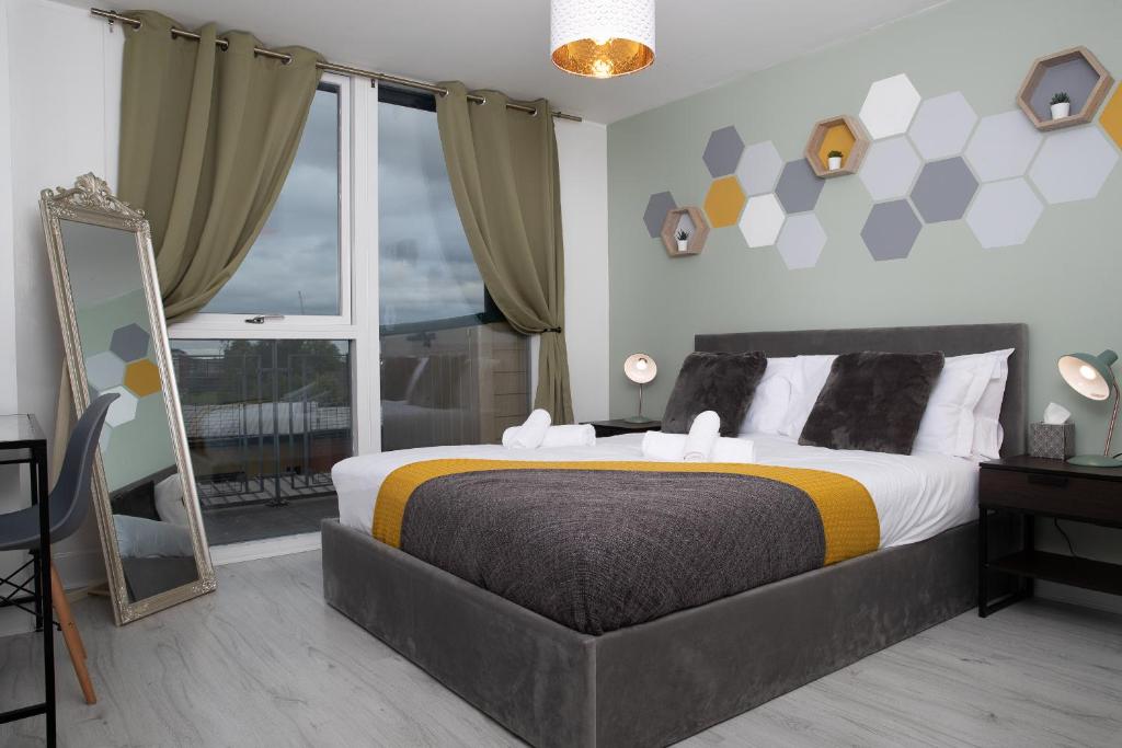 a bedroom with a large bed and a large window at Stylish Birmingham City Centre Apartment in Birmingham