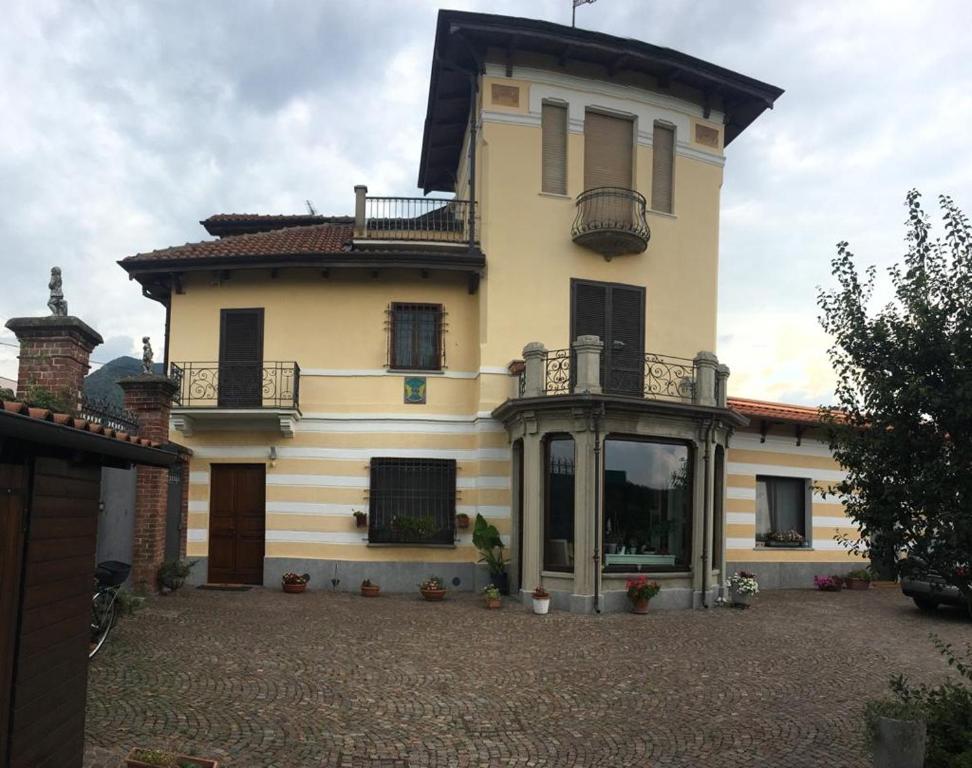 a large yellow house with a balcony on top of it at Elegante Appartamento in Sangano