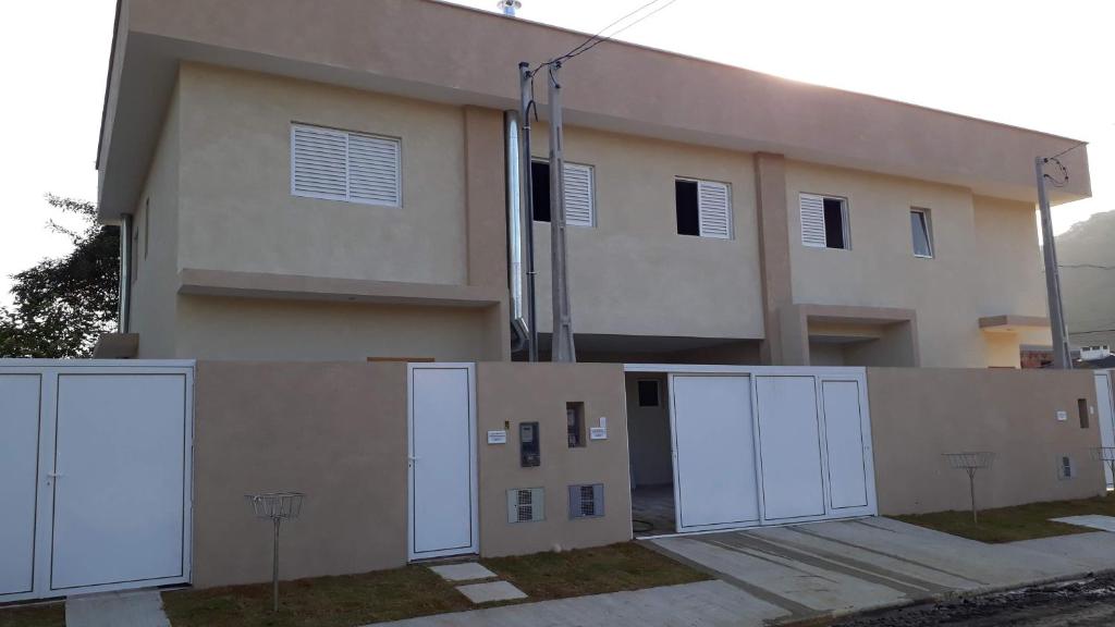 a building with white doors in front of it at LINDO SOBRADO GUARUJÁ in Guarujá