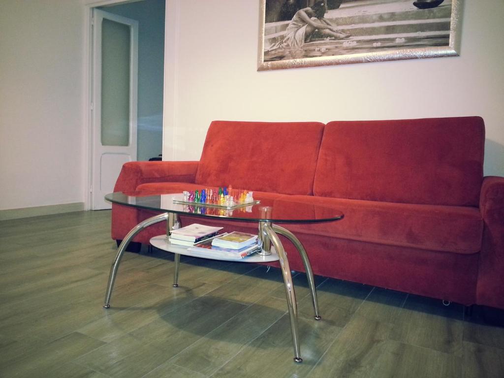 un soggiorno con divano rosso e tavolo in vetro di Appartamento B&B Suite Stefanelli a Taranto