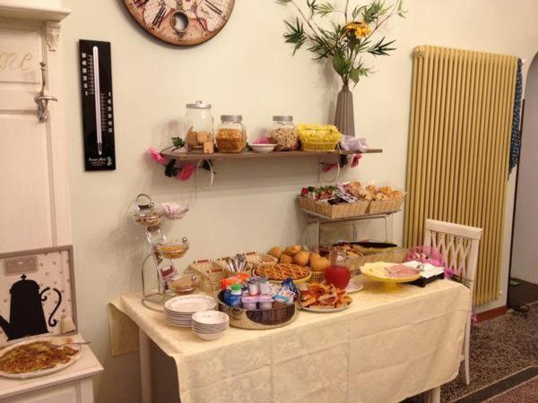 una mesa con comida en ella con un reloj en la pared en Casa dei Mombri, en Noli