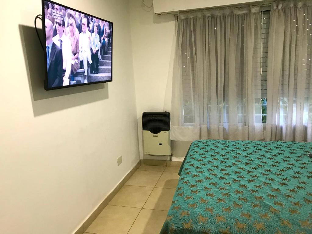 1 dormitorio con TV colgada en la pared en Mandalas 1, amplio apartamento en Belén de Escobar