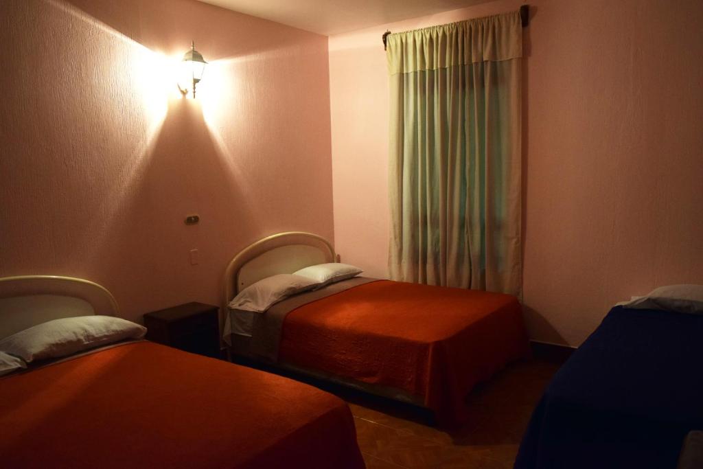 Habitación de hotel con 2 camas y ventana en Hotel Posada del Centro, en Guatemala