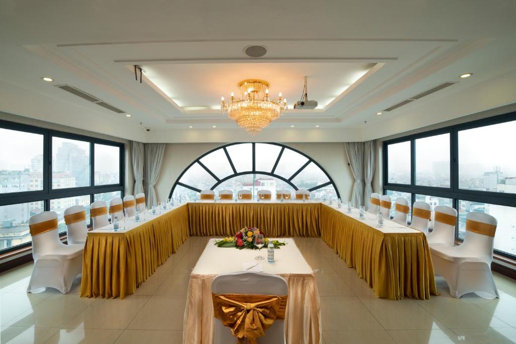 Hanoi Larosa Hotel في هانوي: قاعة المؤتمرات مع طاولة وكراسي طويلة