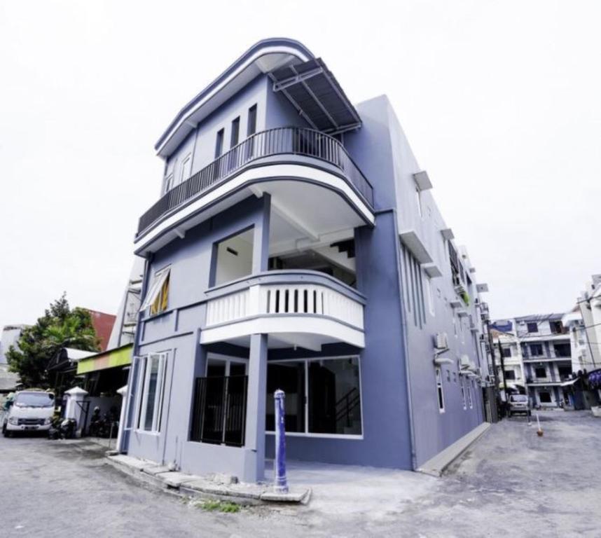 un edificio azul con un balcón en un lateral en Siwalankerto F7, en Surabaya