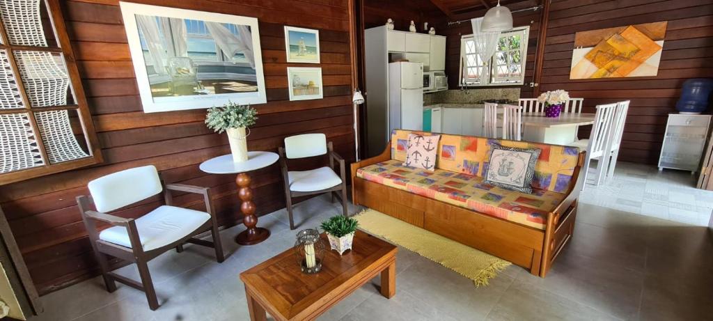 ein Wohnzimmer mit einem Sofa und einem Tisch in der Unterkunft Casa De Madeira in Bombinhas