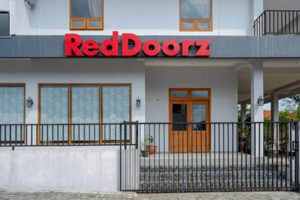 a red door sign on the side of a building at RedDoorz Syariah near Kawasan Sam Poo Kong 2 in Kalibanteng-kidul