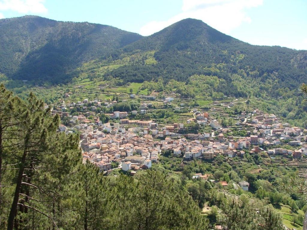 a town in the middle of a valley with mountains at Hotel Barbacedo in Mijares