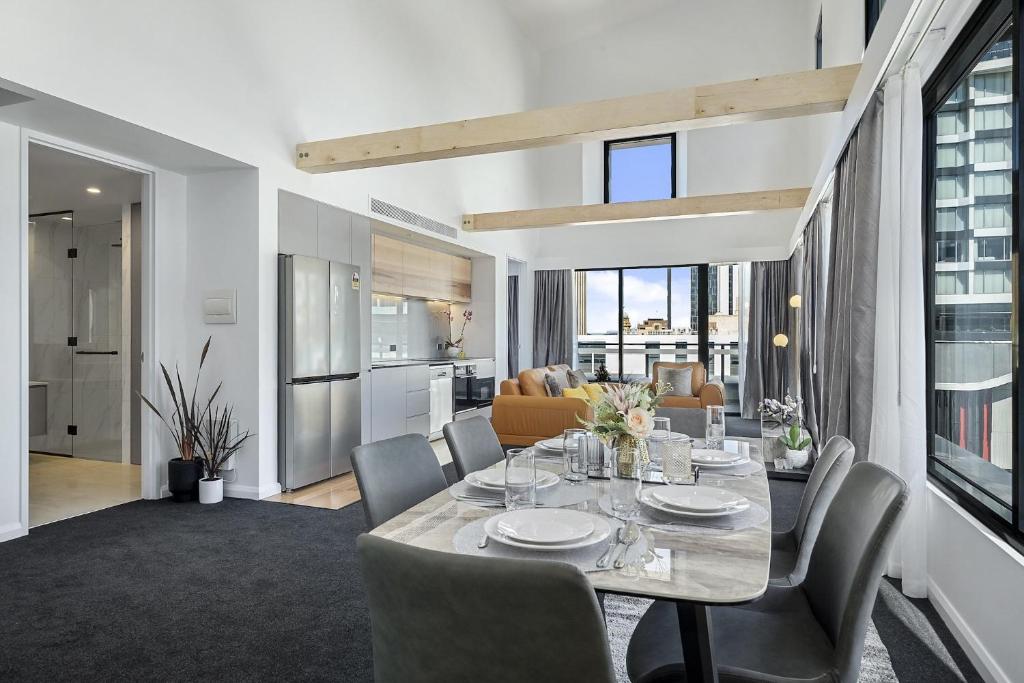 a kitchen with a dining room table and a large window at Hobart City Apartments in Hobart