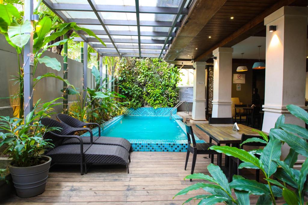a pool in the middle of a patio with a table and chairs at Riva Gold Coast in Candolim