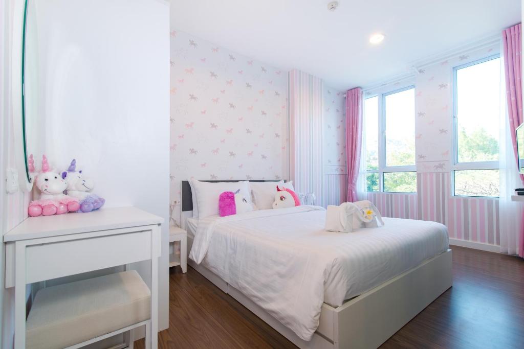 biała sypialnia z białym łóżkiem i oknem w obiekcie Courtyard khaoyai by JP w mieście Mu Si