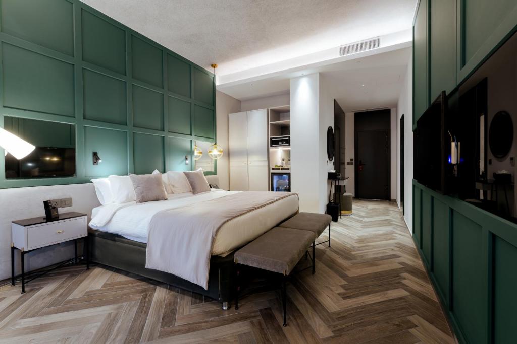 a bedroom with a large bed and a green wall at The Embassy Valletta Hotel in Valletta