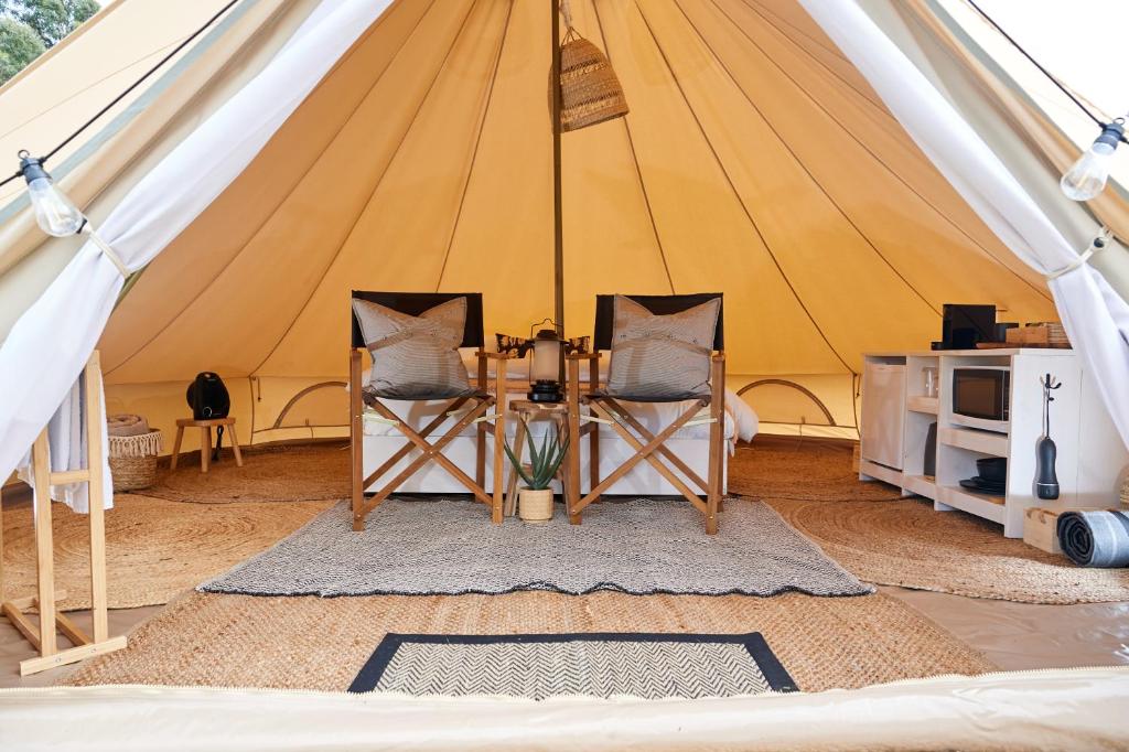 a tent with two chairs and a table in it at Pine Country Caravan Park in Mount Gambier