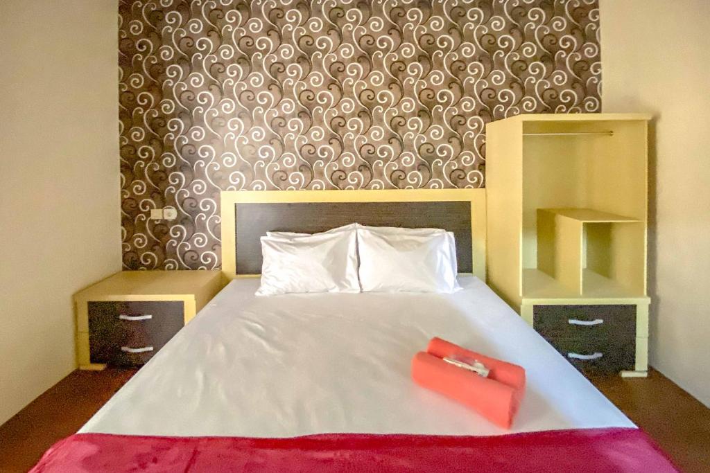 Postel nebo postele na pokoji v ubytování Tini's Guest House Malang Mitra RedDoorz