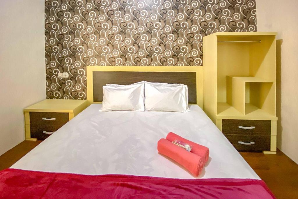 Postel nebo postele na pokoji v ubytování Tini's Guest House Malang Mitra RedDoorz