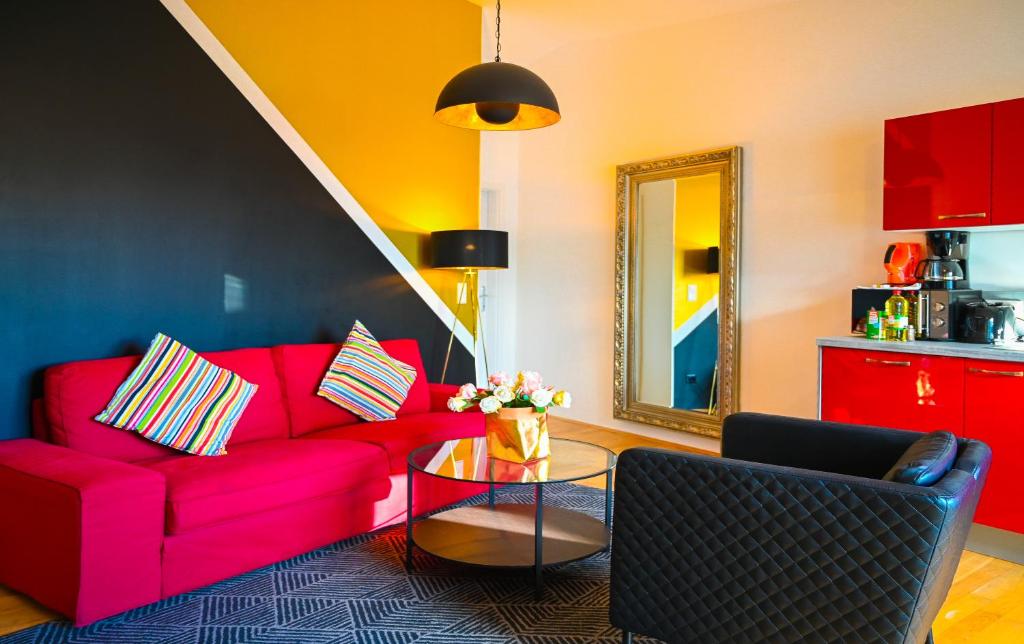 a living room with a red couch and a table at Modern Suite Naschmarkt in Vienna