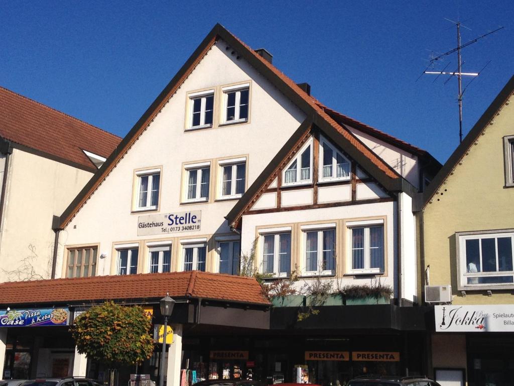 ein großes weißes Gebäude mit braunem Dach in der Unterkunft Gästehaus Stelle in Gammertingen