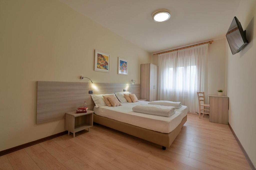 a bedroom with a large bed and a desk at Hotel da Romagnolo in Noventa Vicentina