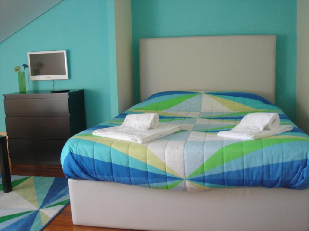 um quarto com uma cama colorida e uma cómoda em CoolHostel em Porto