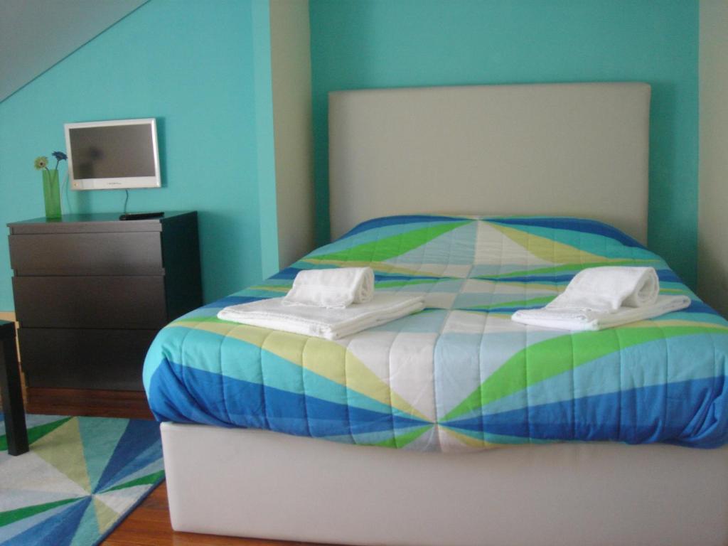 a bed with a blue and white bedspread and pillows at CoolHostel in Porto