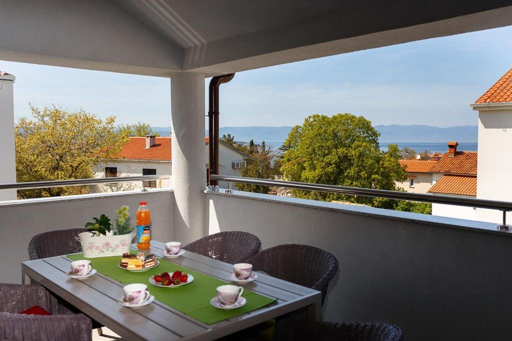 a table on a balcony with a view at Apartment Adria 3 in Malinska