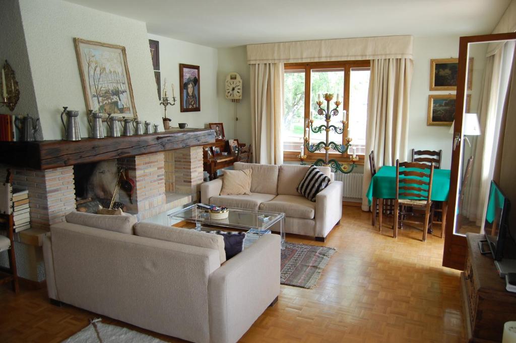 un salon avec deux canapés et une cheminée dans l'établissement CRANS MONTANA LE REGENT APPARTEMENT, à Crans-Montana