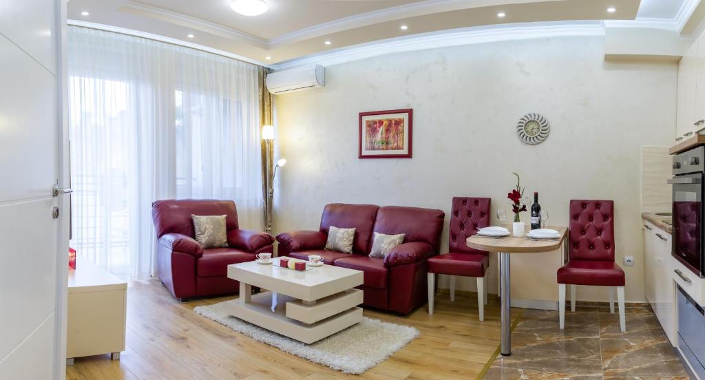 a living room with red chairs and a table at Apartman Boska Lux in Subotica