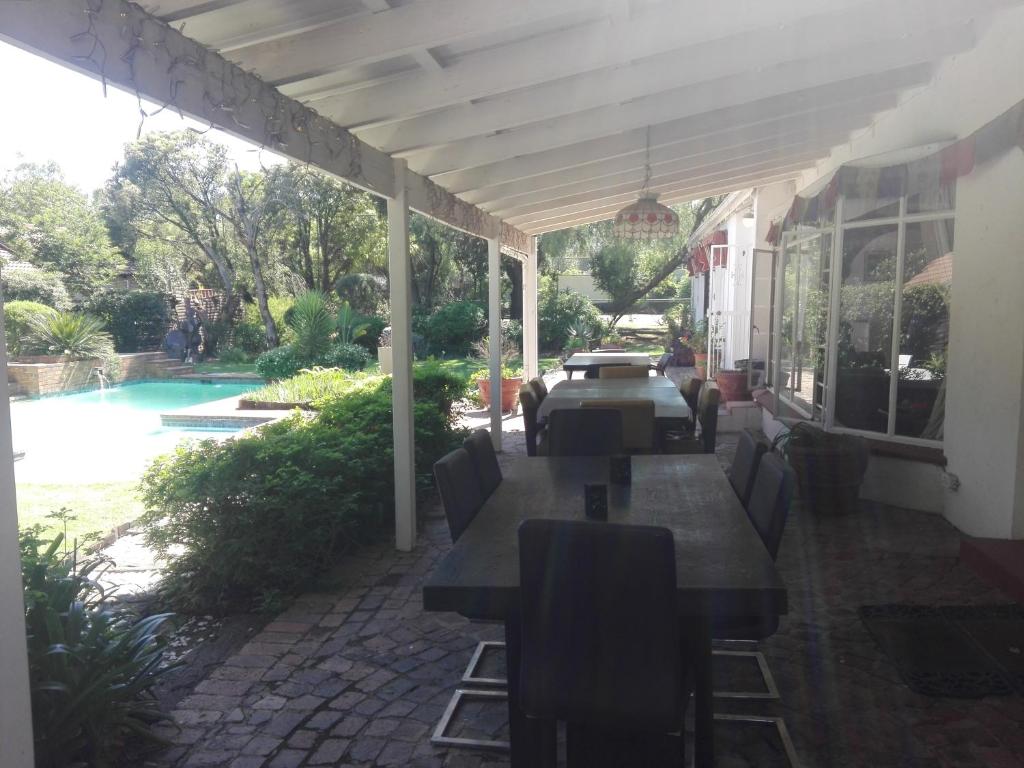 a patio with a table and chairs and a pool at Fourways Guest Lodge in Johannesburg
