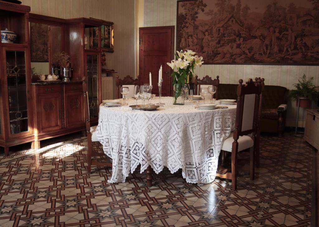 a dining room with a table with a vase of flowers on it at Casa Anna "a lovely home in Tuscany" in Colle Val D'Elsa