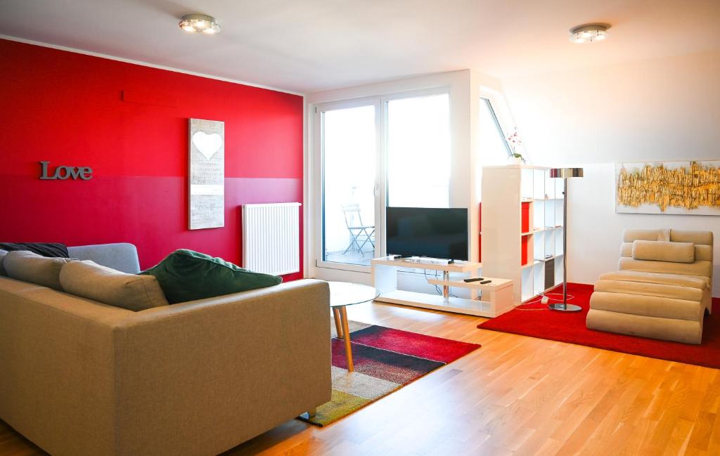 a living room with a couch and a red wall at Modern Duplex Museumsquartier in Vienna