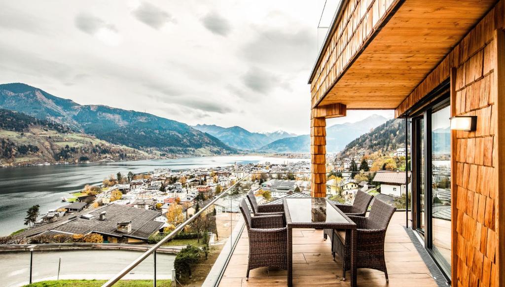 a balcony with a table and chairs overlooking a river at Premium Apartments Adlerhorst by we rent in Zell am See