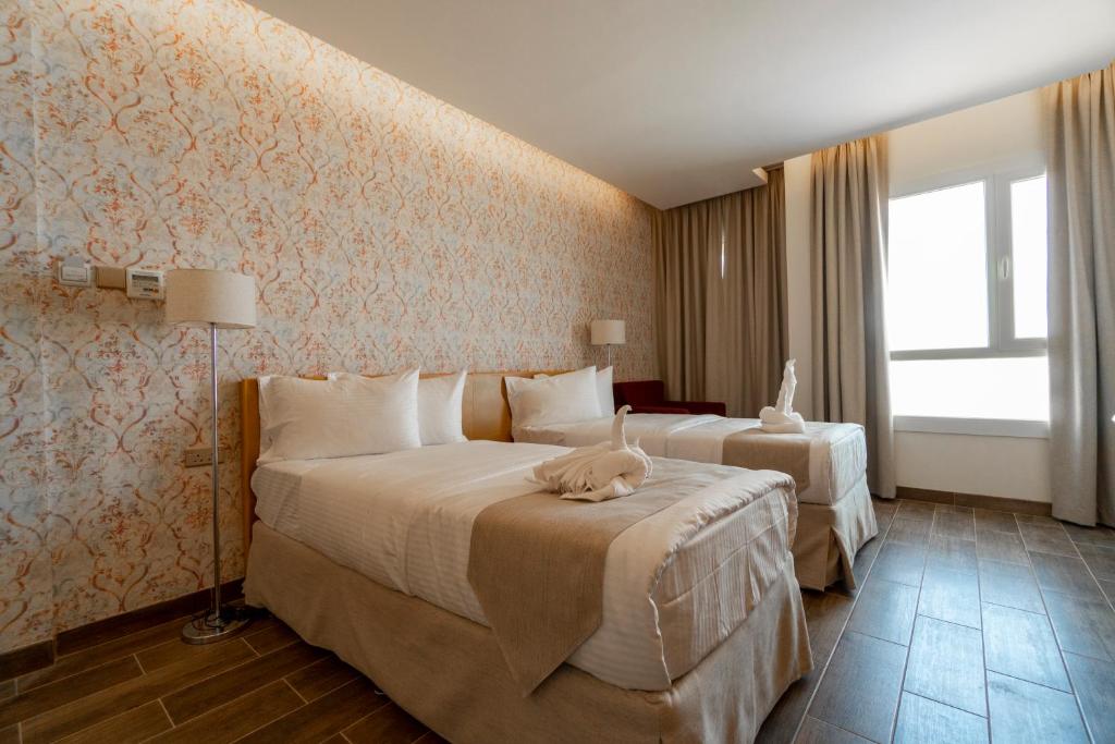 Postel nebo postele na pokoji v ubytování Sama Muscat Hotel