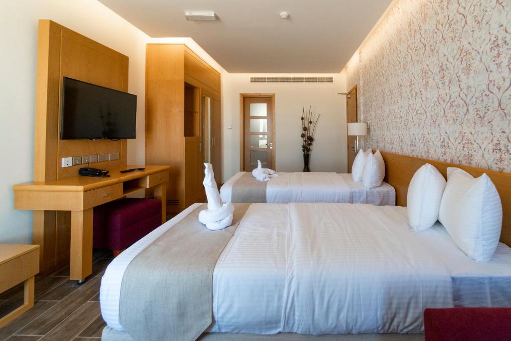 Postel nebo postele na pokoji v ubytování Sama Muscat Hotel