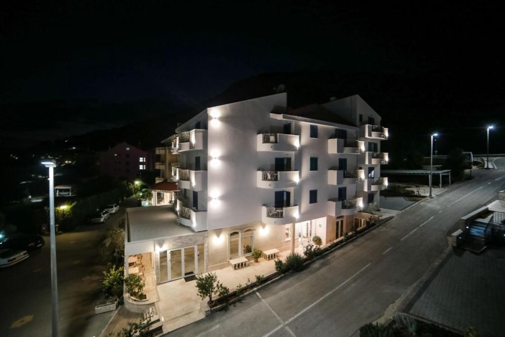 un edificio de apartamentos con luces por la noche en HOTEL IVANDO - K&S, en Drvenik