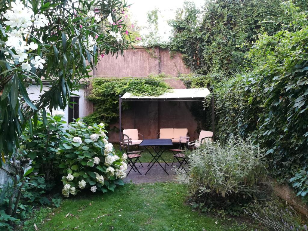ogród ze stołem, krzesłami i kwiatami w obiekcie Accogliente appartamento a Dorsoduro con GIARDINO! w Wenecji