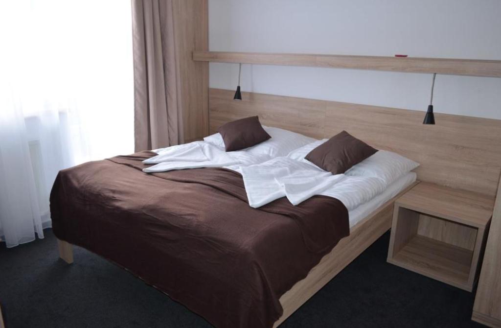 1 cama grande con sábanas y almohadas blancas en Hotel ČESKÁ FARMA en Dolni Dvur
