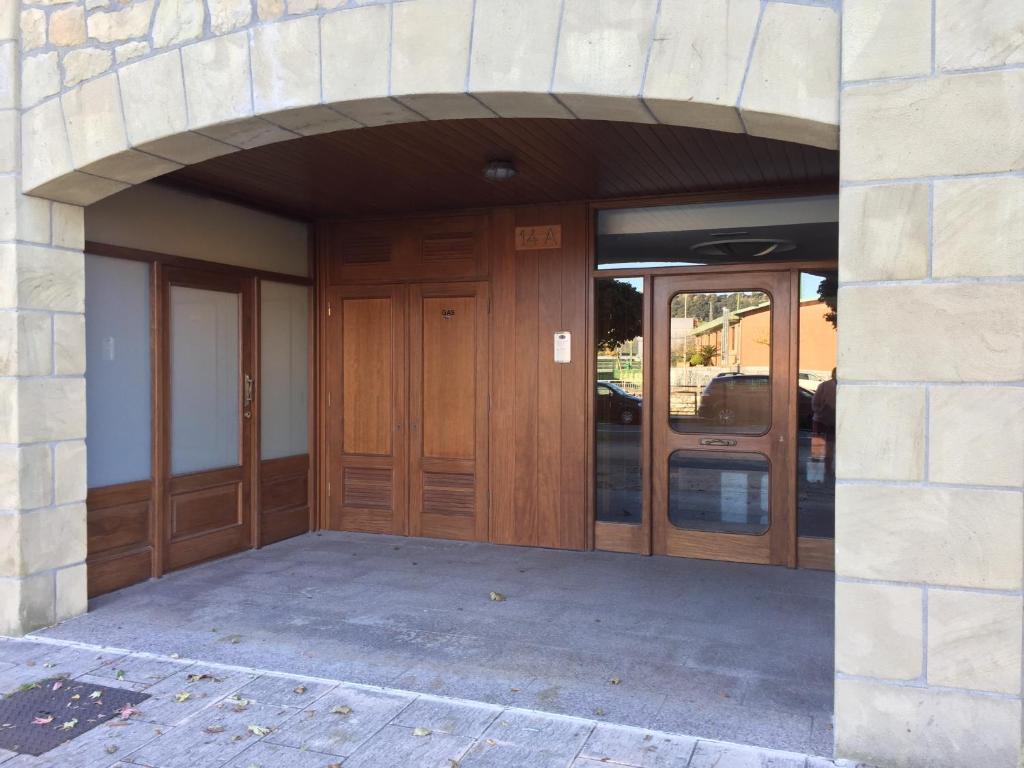 una entrada a un edificio con puertas de madera en Apartamento Costa con Parking Privado Incluido, en Zumaia