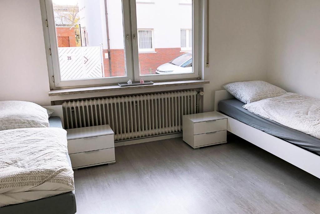 um quarto com 2 camas e uma janela em 3 Zimmer Apartment mit Küche, TV & WLAN em Egelsbach